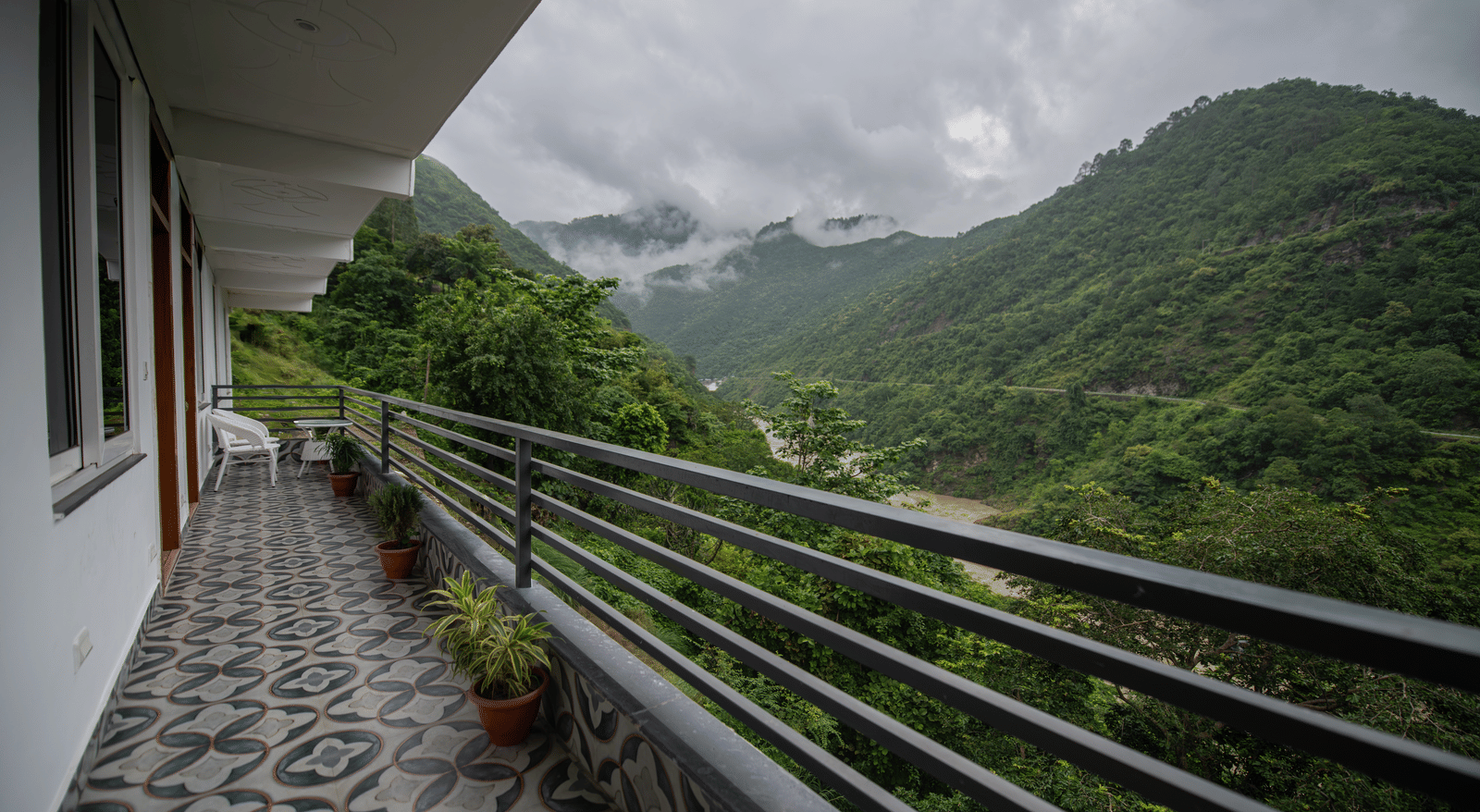A balcony of the standard room at The Tattva Devaprayag with a view of the mountains and the river.