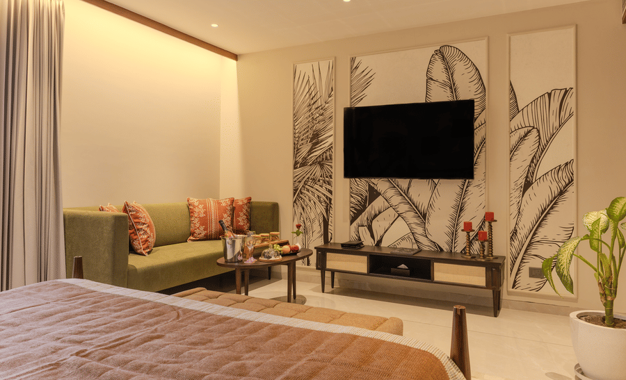 Bright living room with a cushioned sofa, indoor plants and botanical wall art in the  Suite at Hotel Bawa, Udaipur