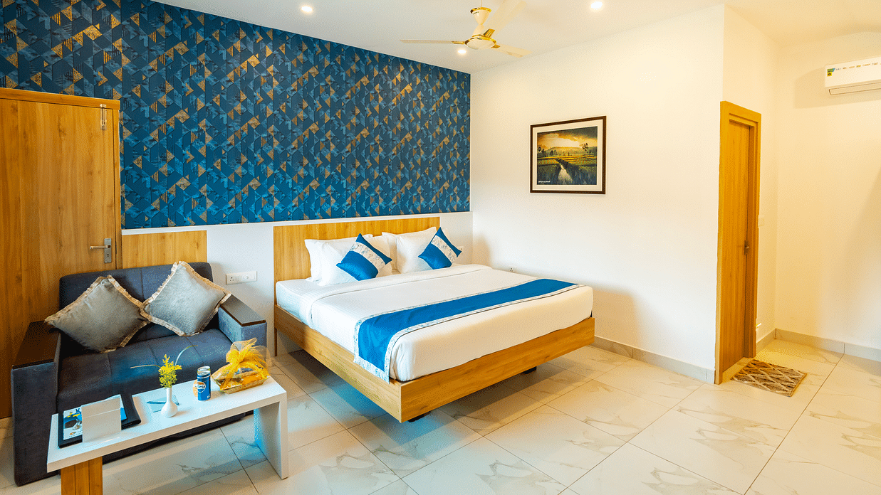  A room with a neatly arranged double bed, a sofa and a coffee table - MGM Whispering Wind's Resorts