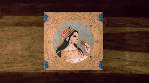 Traditional Rajasthani artwork rests on a wooden table, reflecting the retreat’s cultural depth and subtle incorporation of India’s regal heritage into its décor themes.