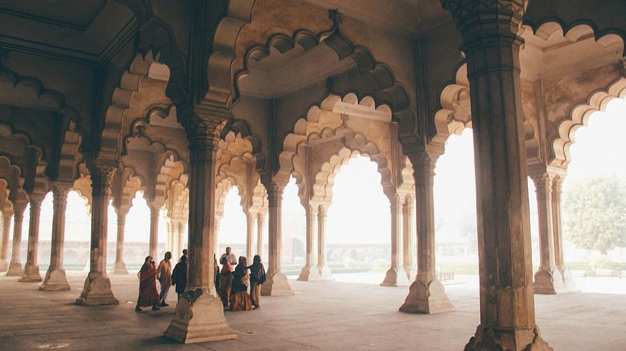 A group of people standing near pillars of a building