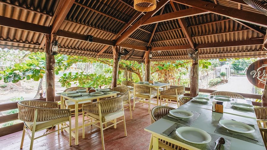 image of the wooden deck with covered seating arrangement surrounded by lush tropical greenery at sibaya beach resort, morjim beach