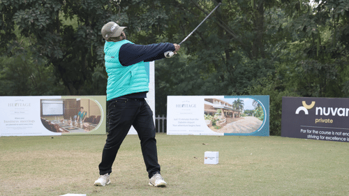 A man playing golf surrounded with lush greenary.- Heritage Village Resorts & Spa