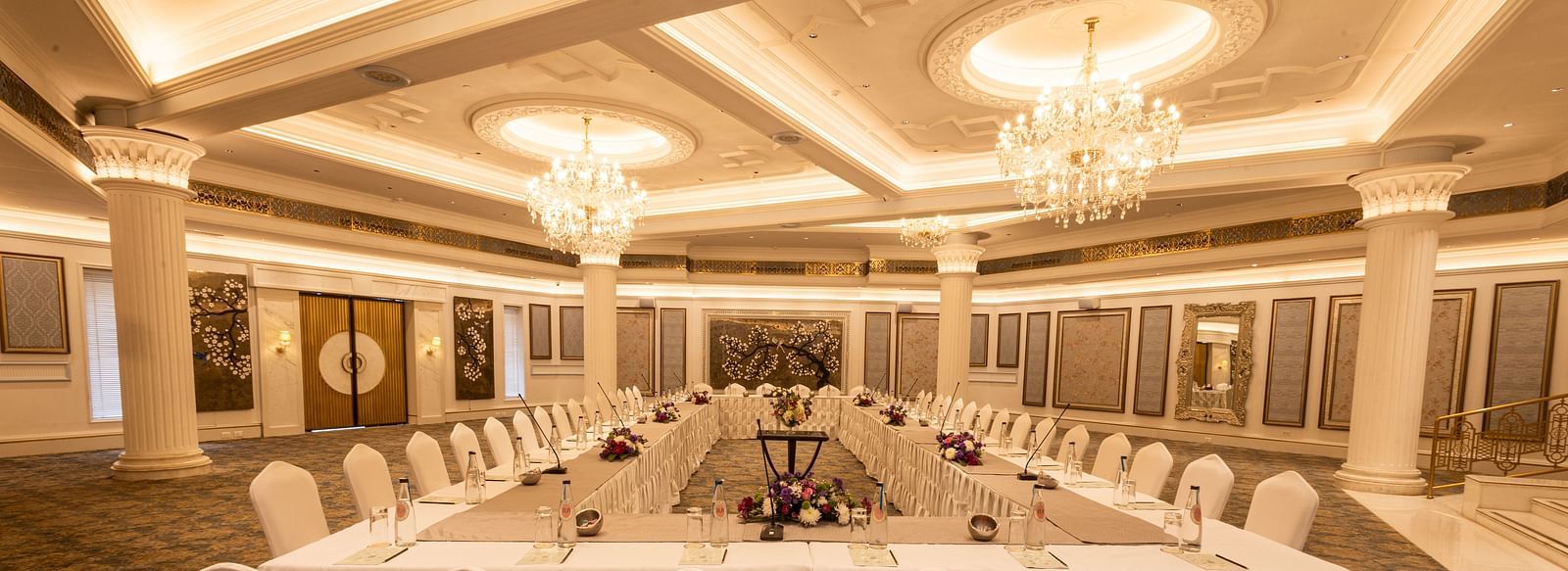 Image featuring the Viceroy Hall event venue at The Claridges New Delhi, showcasing seating arrangements and an elegant chandelier hanging overhead