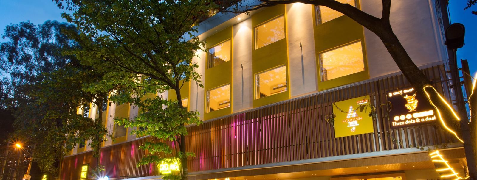 wide view of the facade of the hotel with cars parked outside the front - Hotel Fountain Tree By TGI - JP Nagar, Bangalore