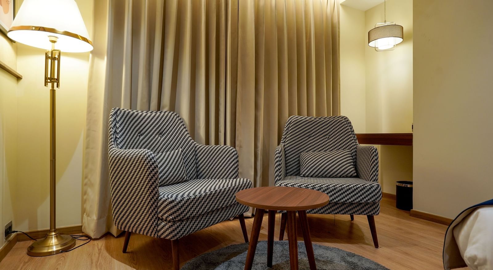 Close-up shot of the common seating area featuring 2 striped armchairs along with a coffee table at M2 Square by Monday Premium.