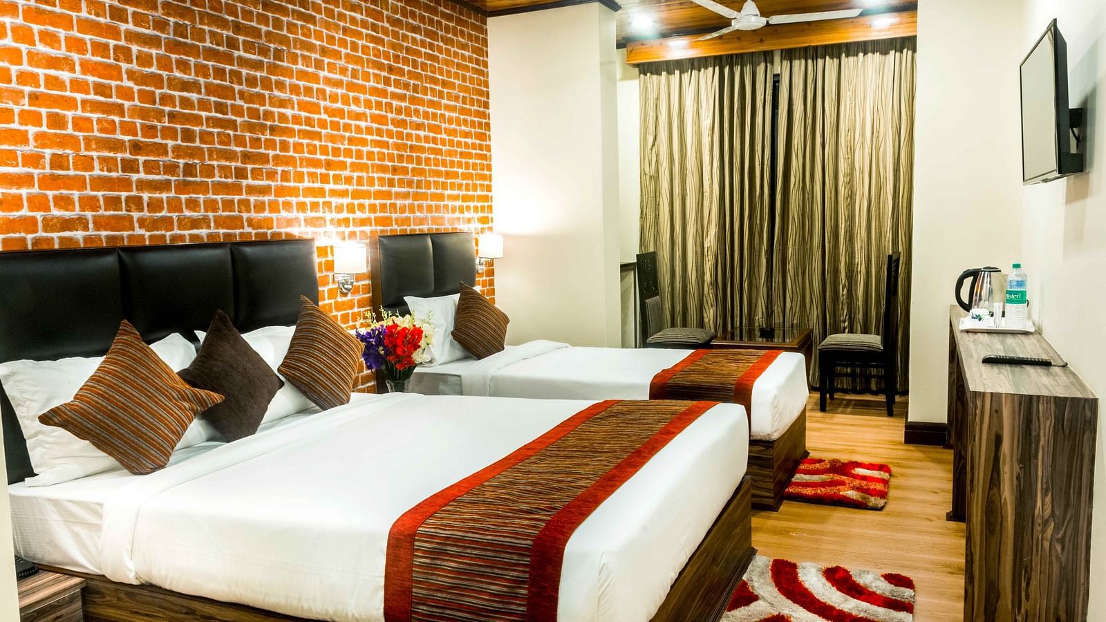 An image of a premium room with with twin beds, bed side tables, flat screen tv, chairs and tables, and other amenities - Ecotel Tin Tin, Bijanbari