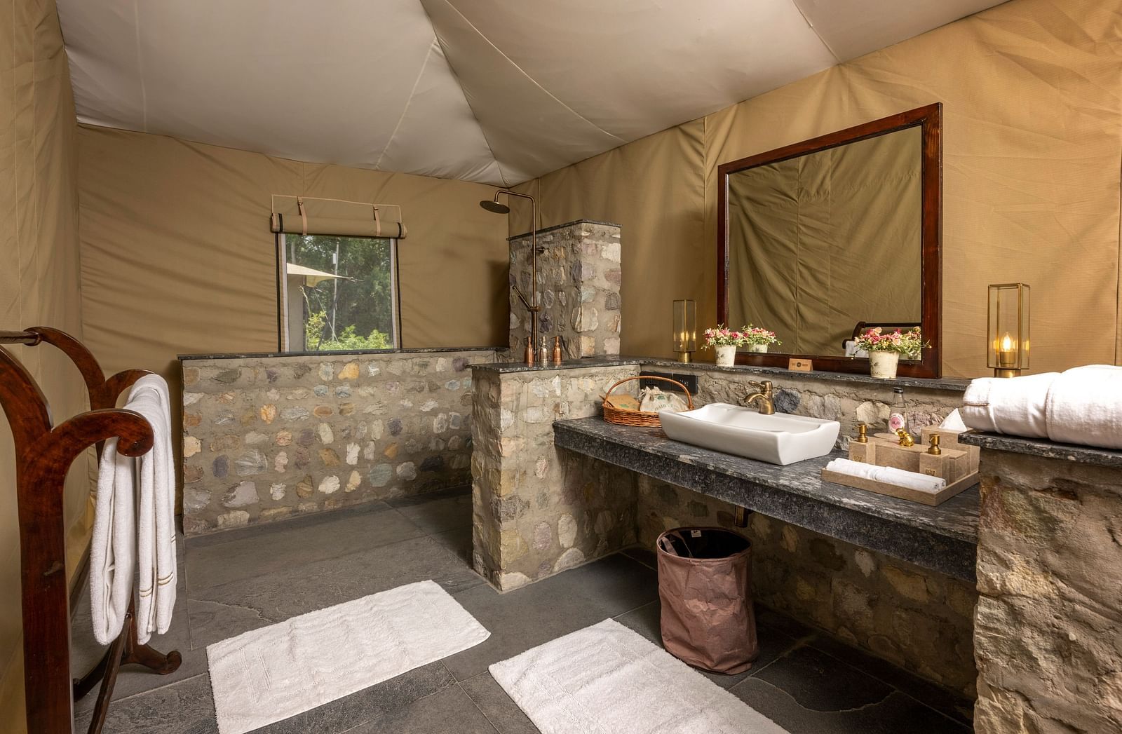 An image of a bathroom with a mounted mirror and toiletry essentials in our tents near Haridwar - Aalia Jungle Resort & Spa