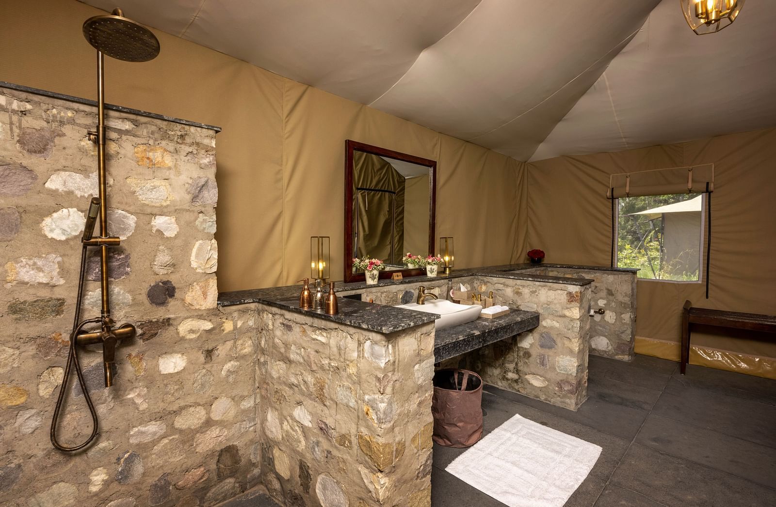 An image of a bathroom with a wall-mounted mirror, a shower and toiletry essentials in our resort near Haridwar - Aalia Jungle Resort & Spa