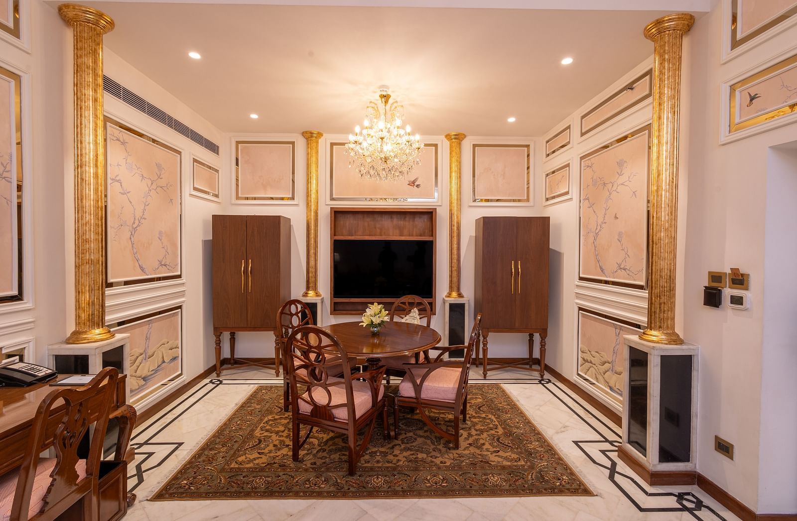 Luxury Suite at The Claridges New Delhi, showcasing a corner view of the room with a stylish dining table and an elegant chandelier hanging overhead