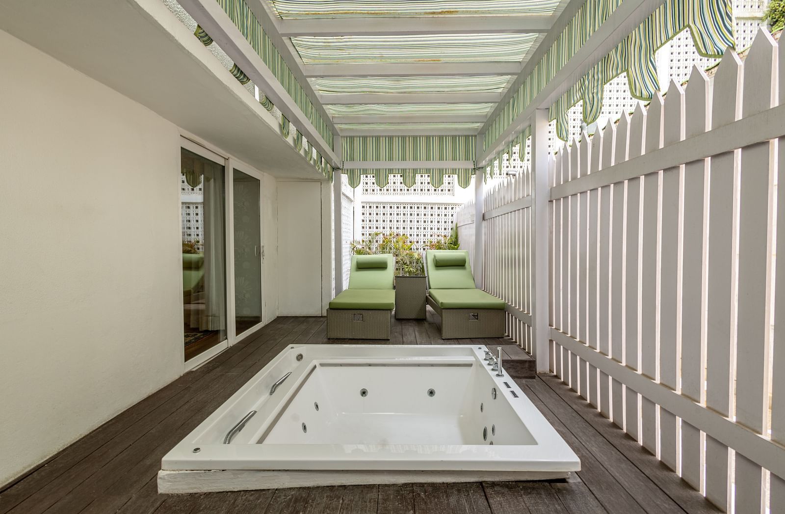 Luxury Suite with Whirlpool at The Claridges New Delhi, featuring a private small pool under a shaded area and lounge chairs arranged in the corner