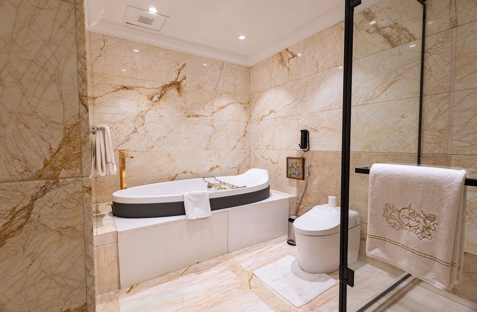 Presidential Suite washroom at The Claridges New Delhi, featuring a luxurious bathtub and a glass-enclosed bath area