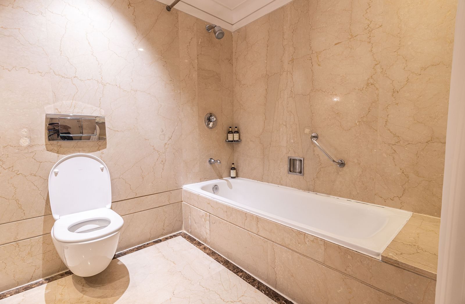 image of a well appointed bathroom highlighting the bathtub and a commode - The Claridges New Delhi 