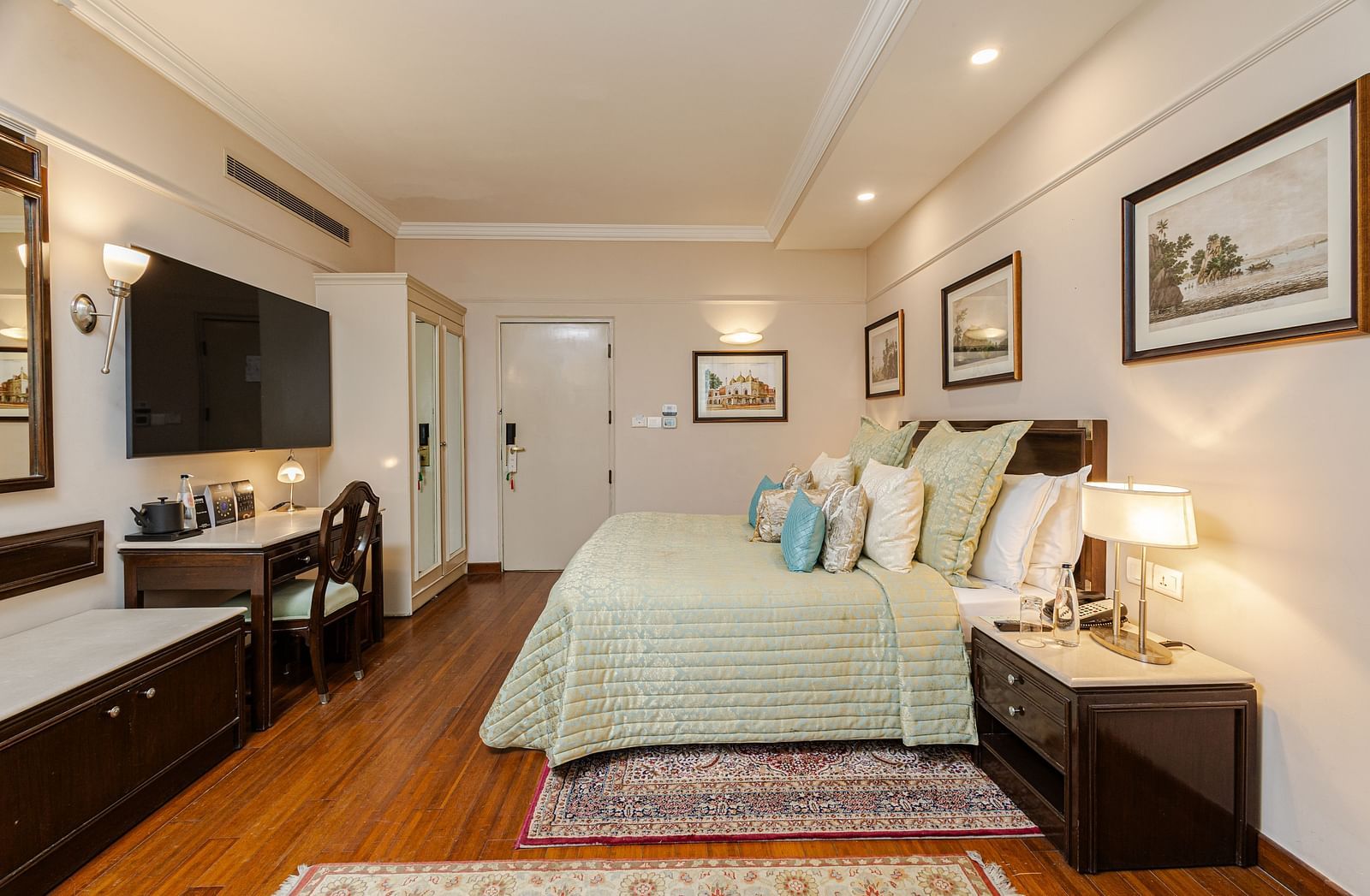 image of the boutique room brightly lit with a wall mounted tv opposite to the bed - The Claridges New Delhi