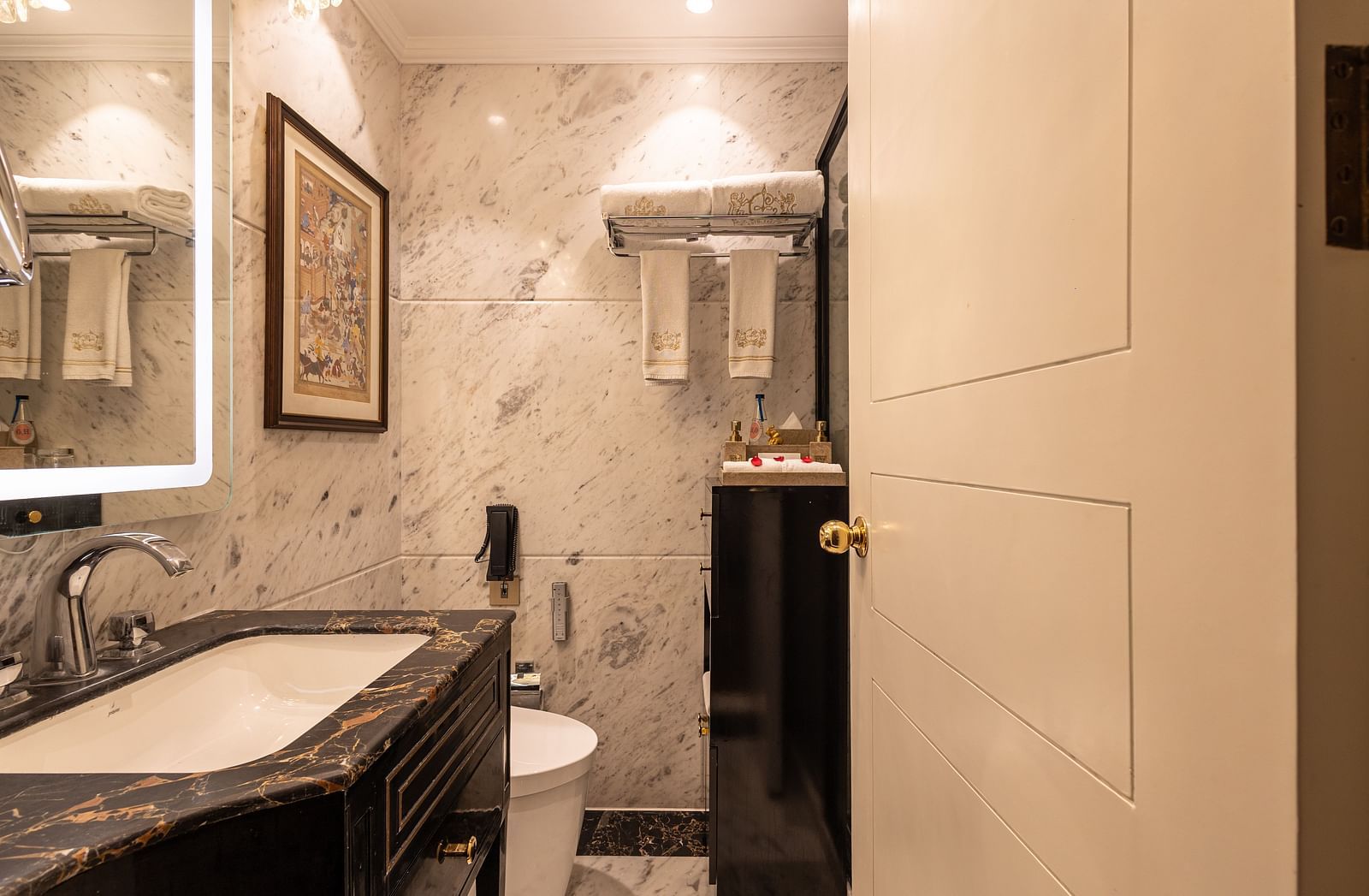 Washroom of the Luxury Twin Bed Room with Balcony at The Claridges New Delhi, featuring a modern sink and a stylish wall-mounted mirror