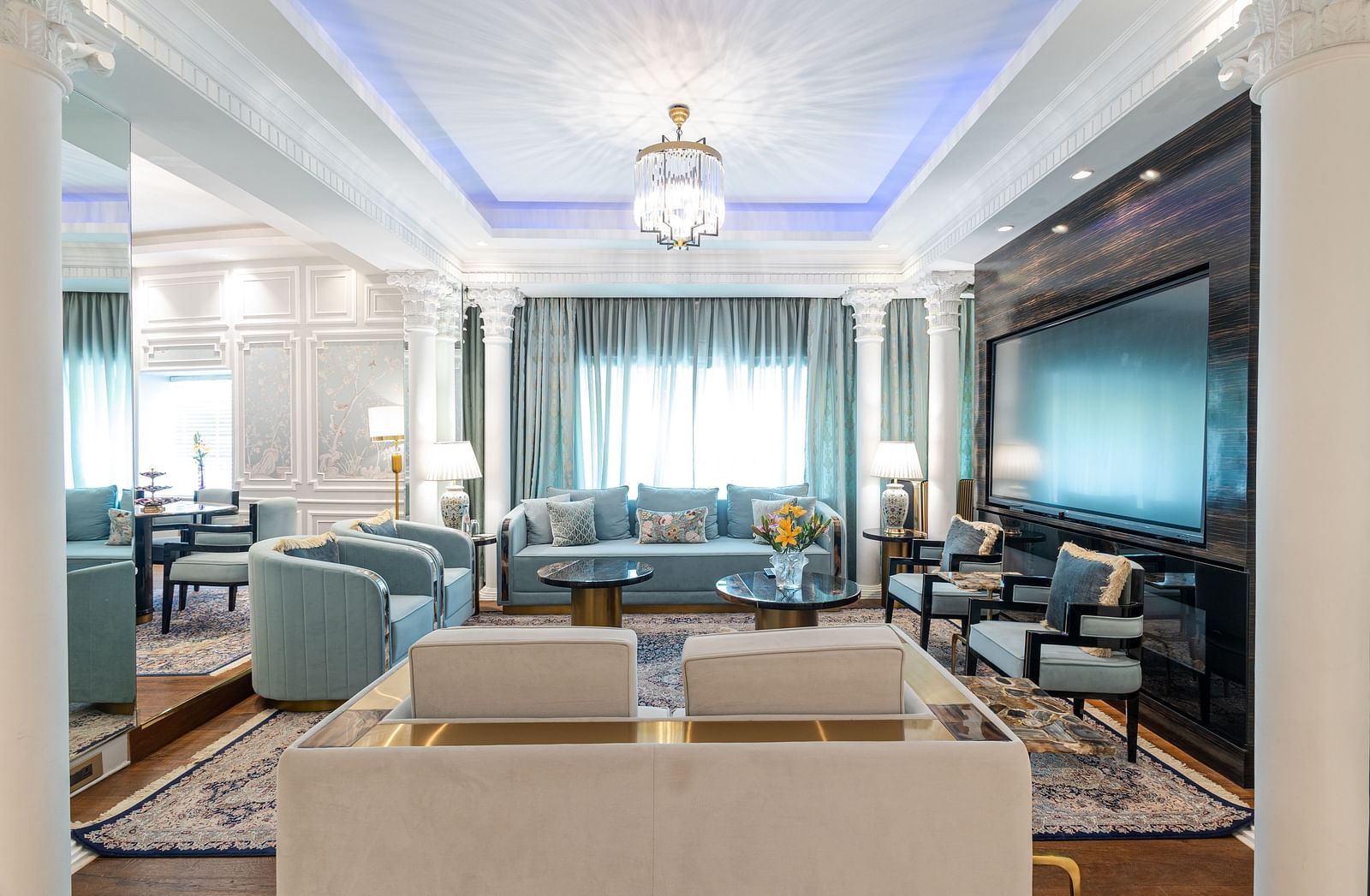 an image of the living room with ample of seating space and a wide wall mounted television at our diplomatic suite room - The Claridges New Delhi