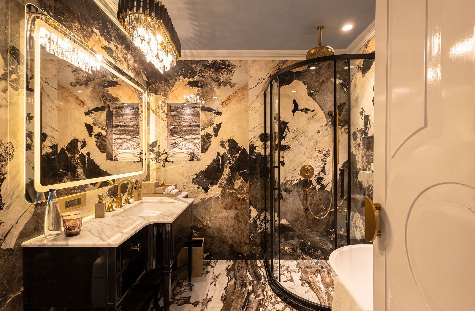 A sophisticated bathroom featuring a white and black gradient marble design and a spacious mirror above the wash basin in the Heritage Parlour Suite - The Claridges New Delhi
