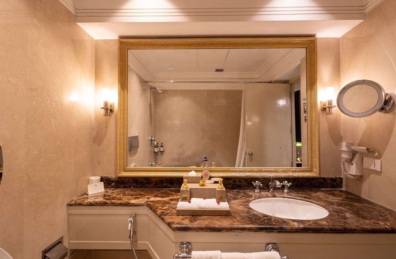 Washroom of the Superior Twin Bed Room at The Claridges New Delhi, featuring a sleek sink and a wall-mounted mirror
