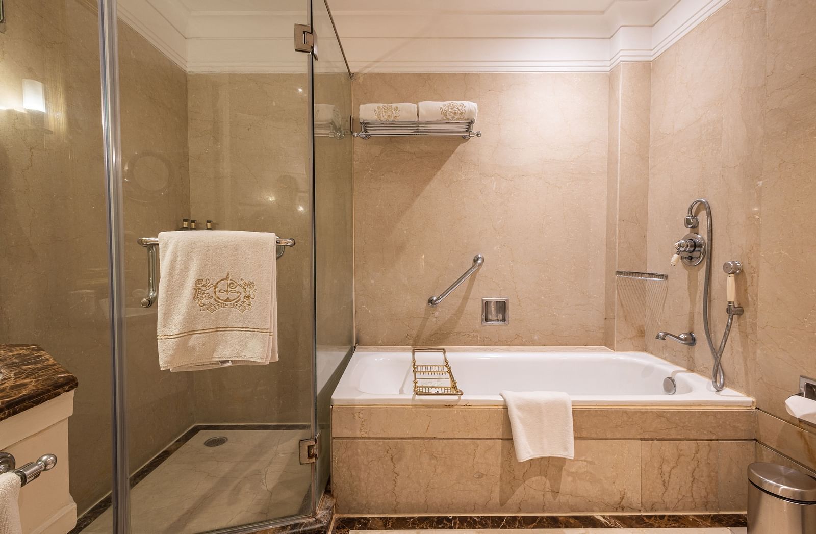 Washroom of the Grand Luxury Twin Bed Room at The Claridges New Delhi, featuring a spacious bathtub and a glass-enclosed shower area