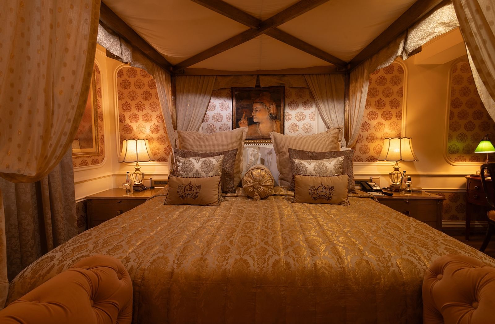 A front view of the Heritage Parlour Suite bed, adorned with a Mughal style painting elegantly positioned on the wall behind the headboard - The Claridges New Delhi