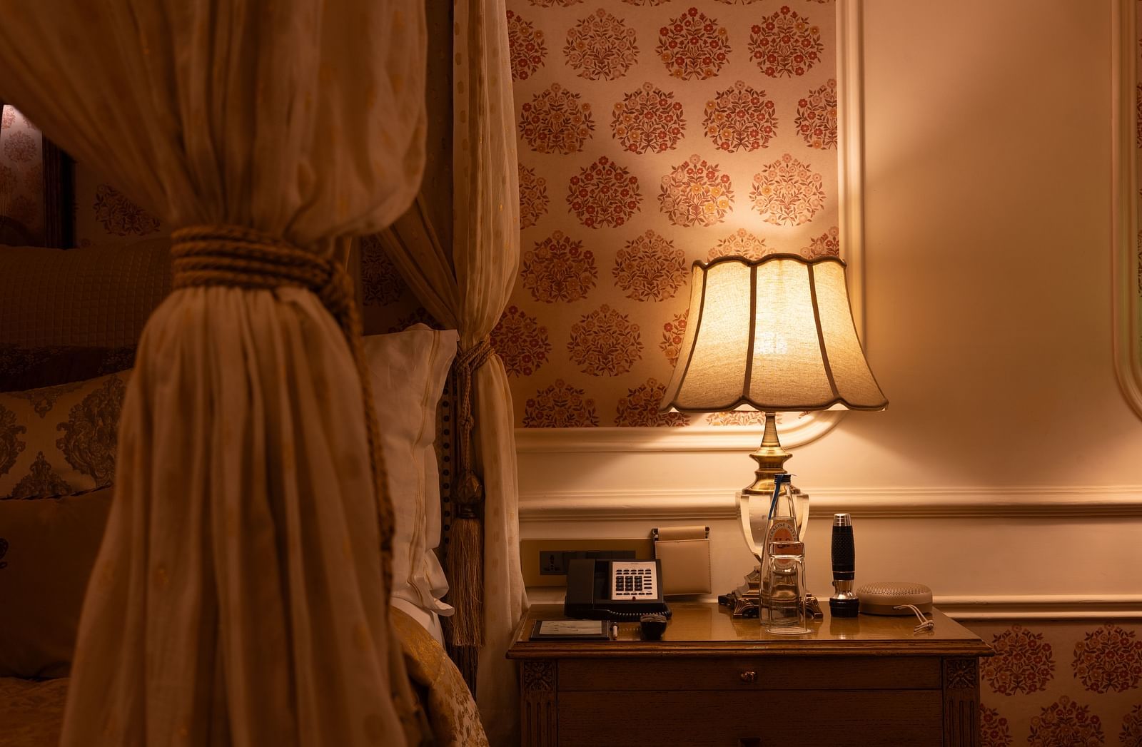 a close up shot of the table lamp besides the plush bedding at the bedroom of our heritage parlour suite - The Claridges New Delhi