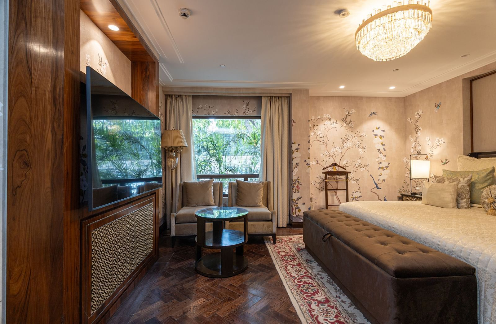 Image of the Cabana Room displaying two single-seater couches and a wall-mounted television - The Claridges New Delhi