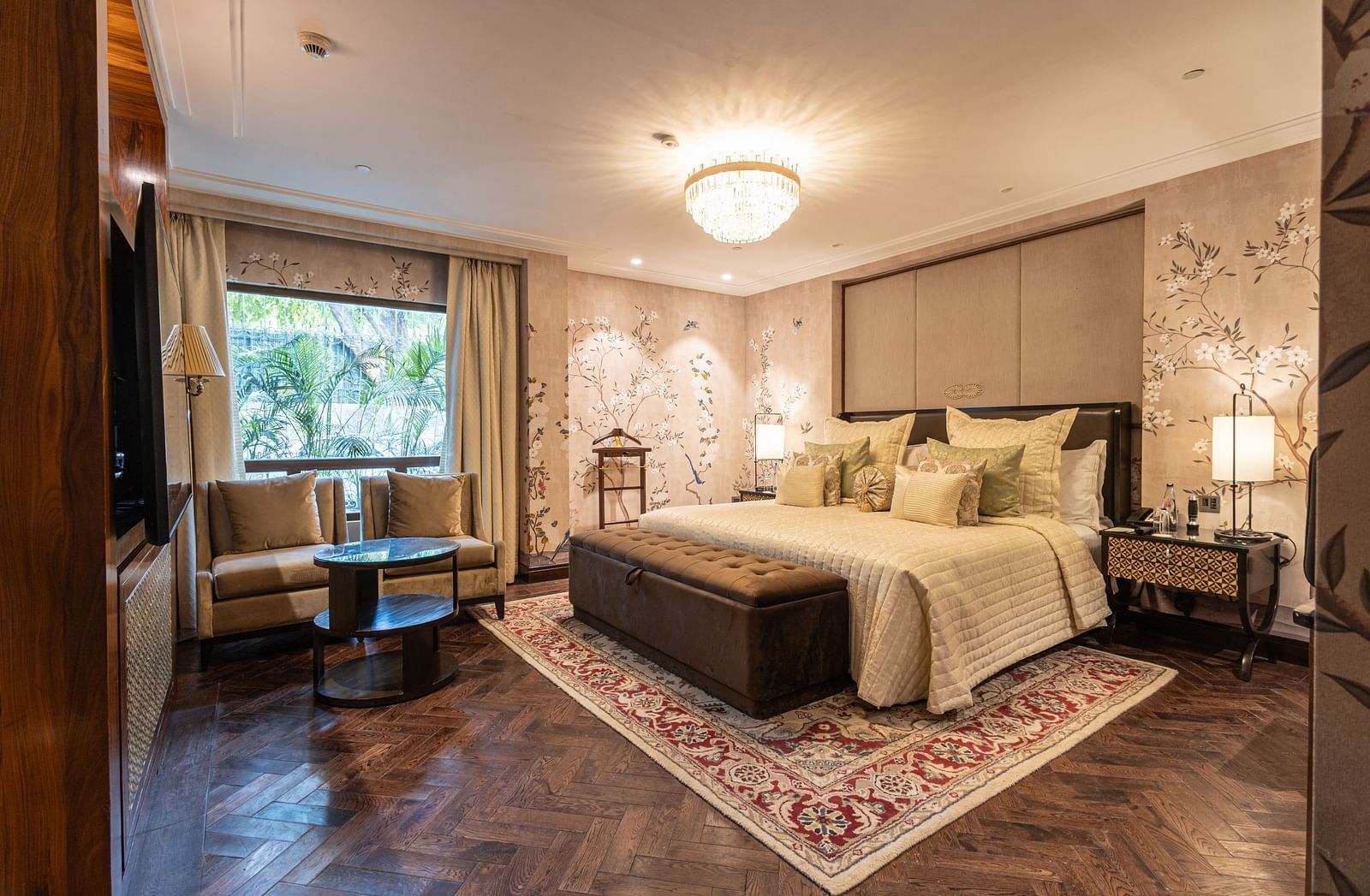 image of the bedroom of the cabana room featuring a modern interior with grey themed colour tone - Image of the Cabana Room featuring two single-seater couches and a wall-mounted television - The Claridges New Delhi