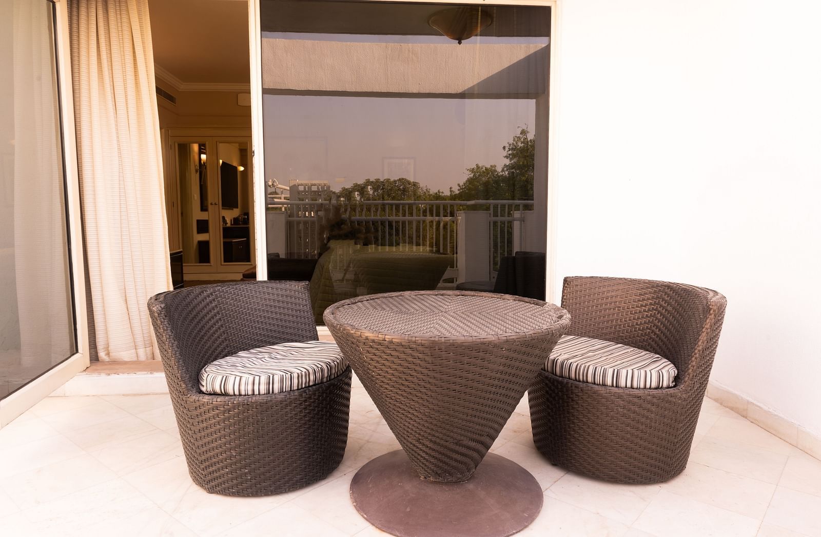 outdoor seating area with a coffee table at the heritage terrace room - The Claridges New Delhi