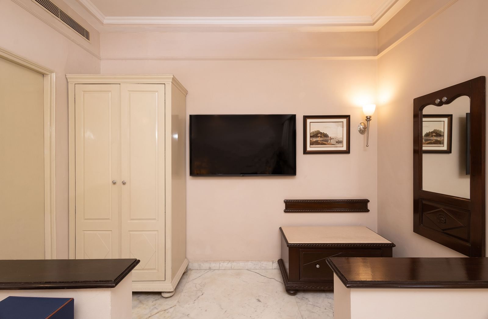 an image of a two column wardrobe with a wall mounted tv in the heritage parlour room - The Claridges New Delhi