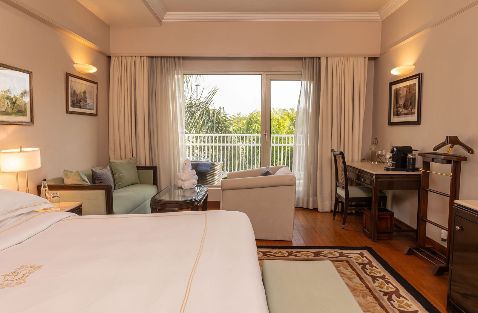 image of the king sized bed with french windows at the far end of the room at our heritage balcony room - The Claridges New Delhi