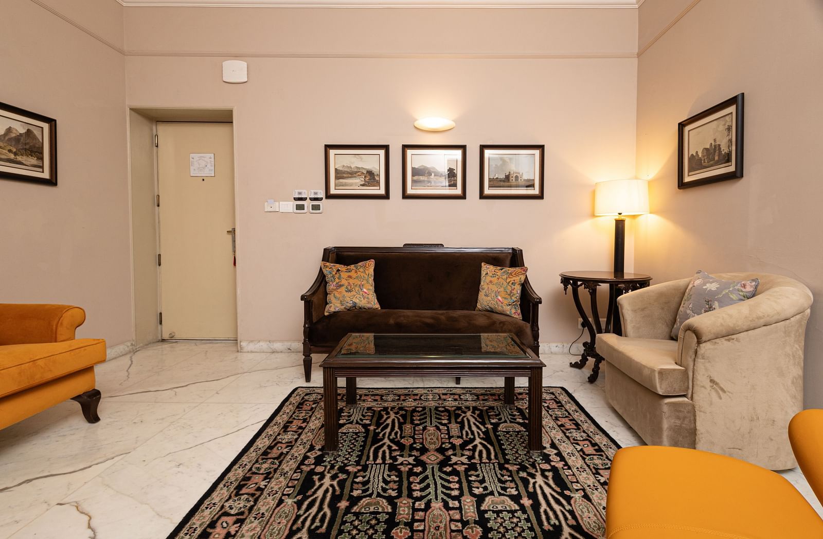image of the living area of the heritage parlour room with a three seater brown couch and a white couch - The Claridges New Delhi
