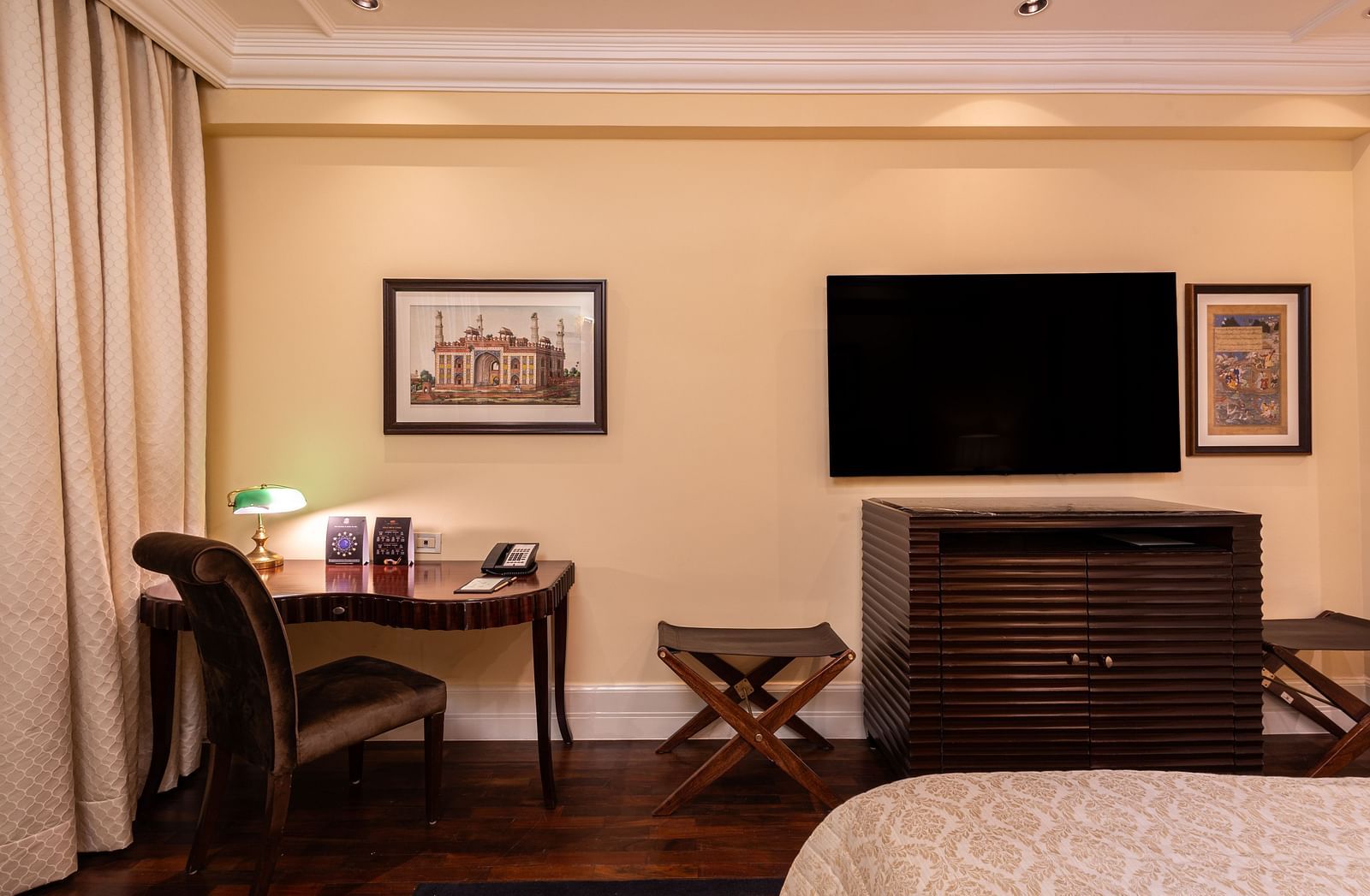 image of the heritage parlour room showcasing the work desk and the wall mounted tv above a hard wood cabinet - The Claridges New Delhi