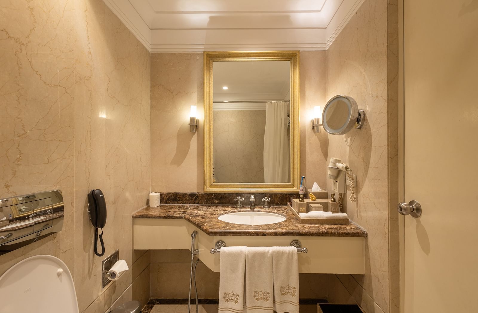 image of the sink with a rectangular mirror above it at our heritage balcony room -image of the heritage balcony room with sleek interiors and a a plush king size bed - The Claridges New Delhi