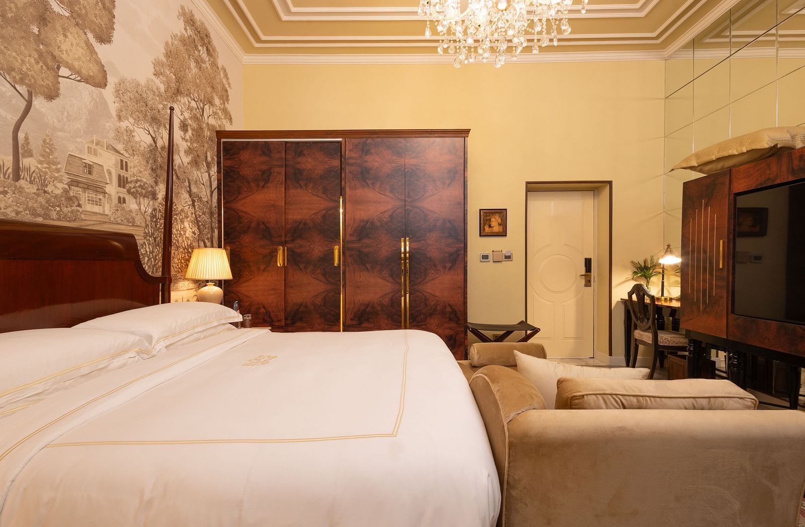 image of the heritage room featuring a soft king size bed with hardwood wardrobe besides it - The Claridges New Delhi