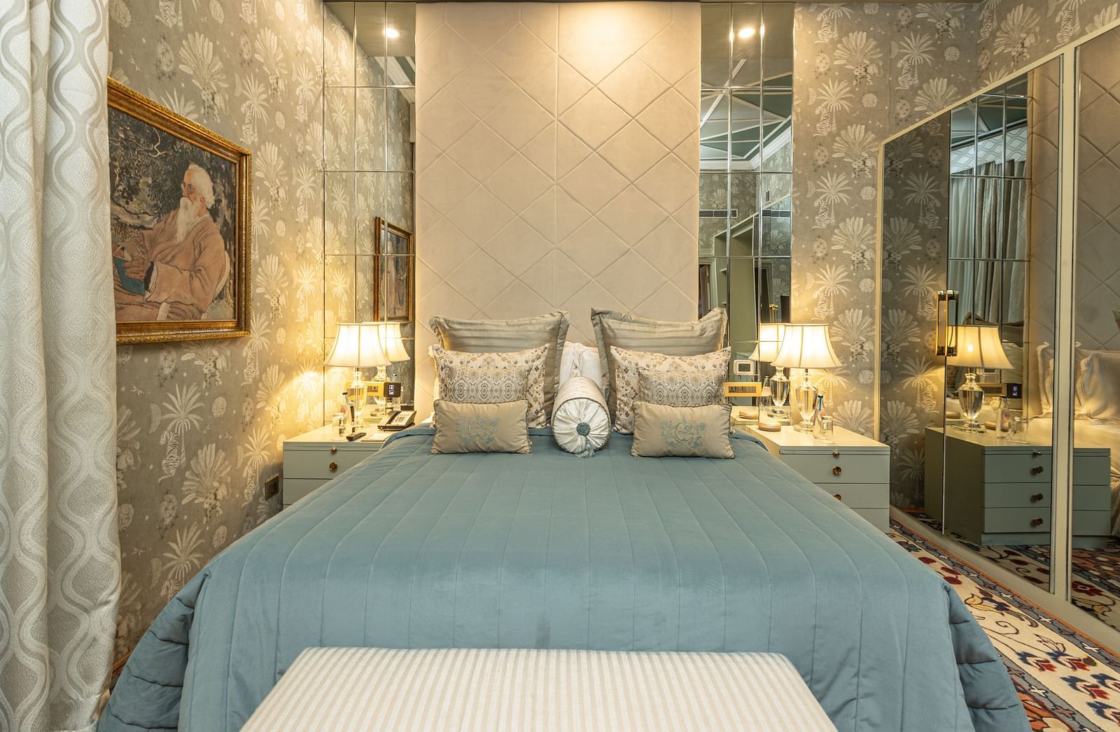 image of a king size bed with a teal blue comforter spread over the bed at our heritage luxury suite - The Claridges New Delhi