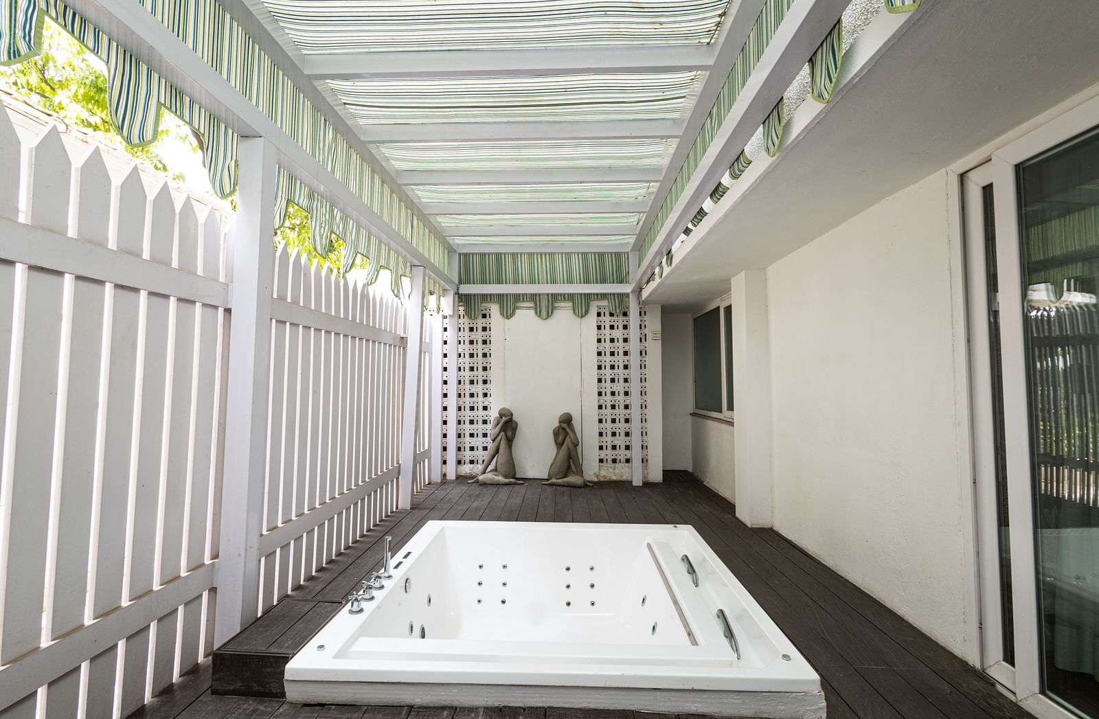 a bright image of the outdoor whirlpool with hard wood porch at our heritage luxury suite - The Claridges New Delhi
