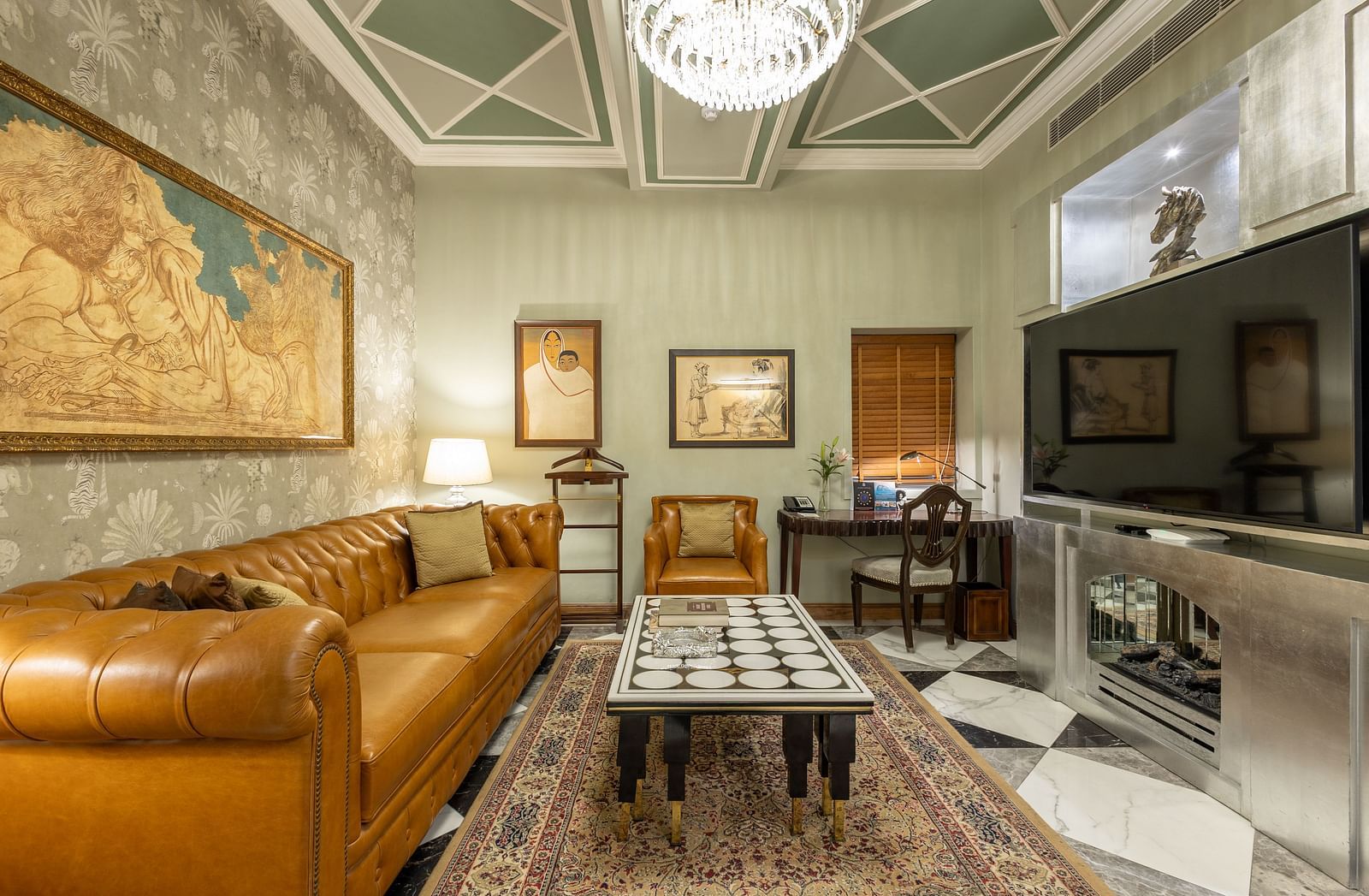full view of the living room with huge photo frames and a comfortable elegant couch at our heritage luxury suite - The Claridges New Delhi
