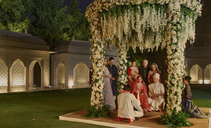 A traditional Indian wedding ceremony at night, with the bride and groom under a beautifully decorated floral canopy at Heritage Village Resorts & Spa, Manesar - One of the best Destination Wedding Venues Near Delhi.