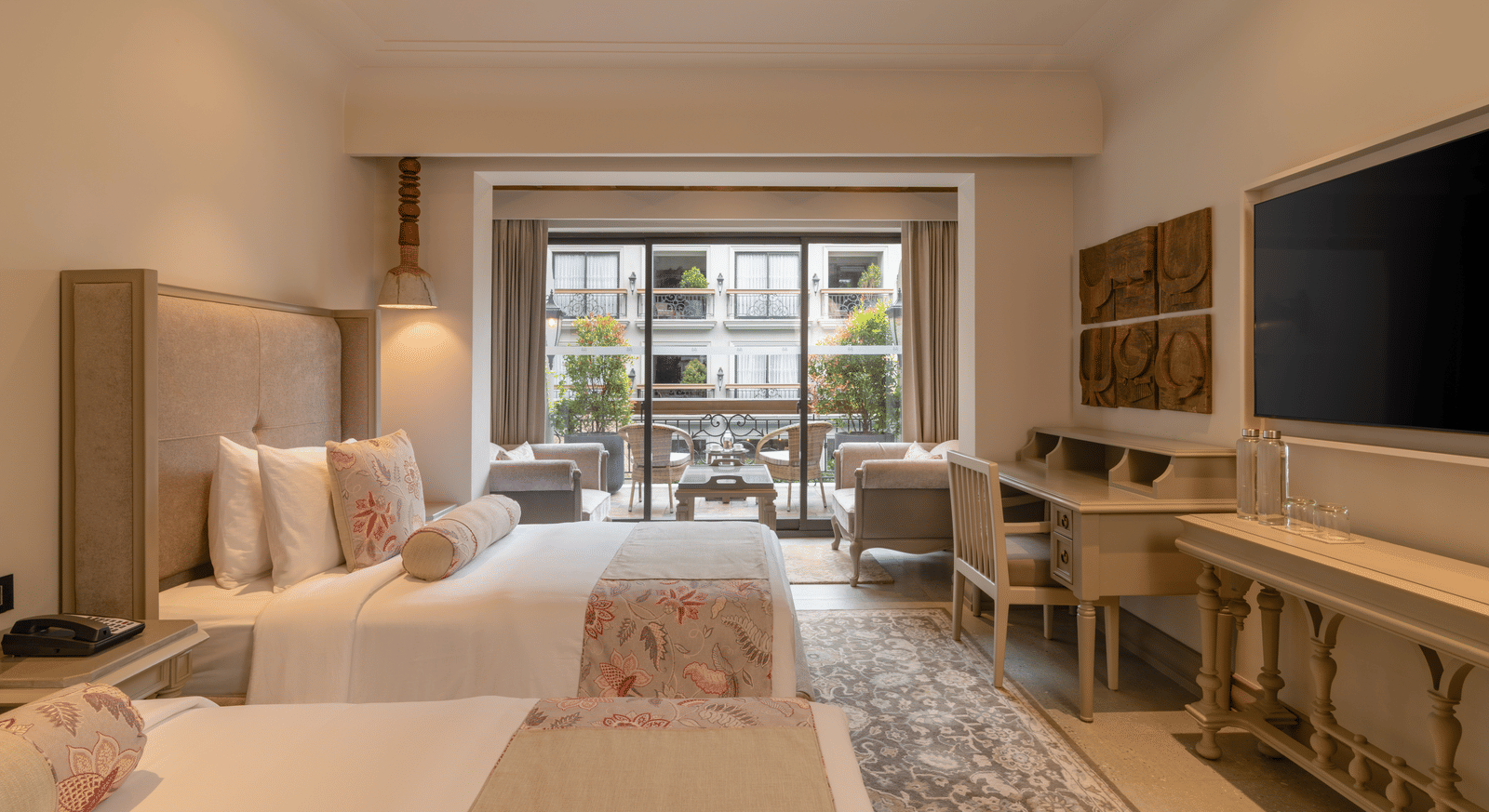 Side view of the Premium Room with a twin bed featuring wide french windows at the far end of the room at The Evren, Vagator.