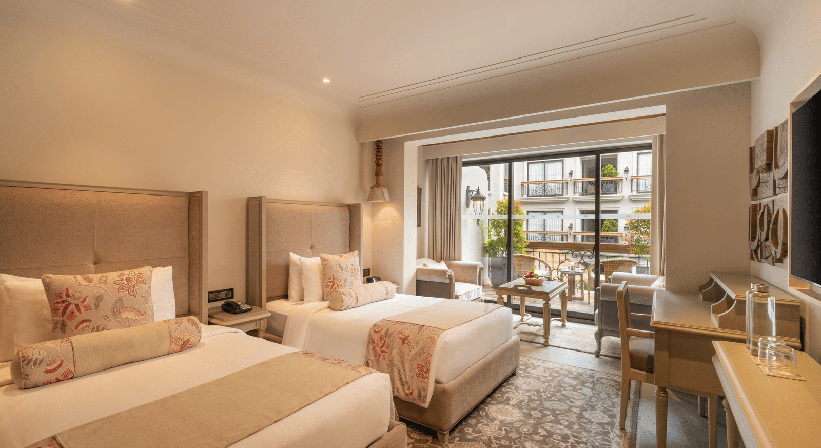 Corner view of the Premium Room with with beds at The Evren, Vagator, with ample of natural light coming from the french windows.