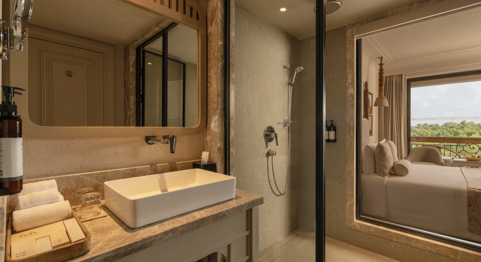 A neatly-kept vanity area with a rectangular mirror above it at the Classic Room (Diwa), seaprated by a glass partition at The Evren, Vagator.