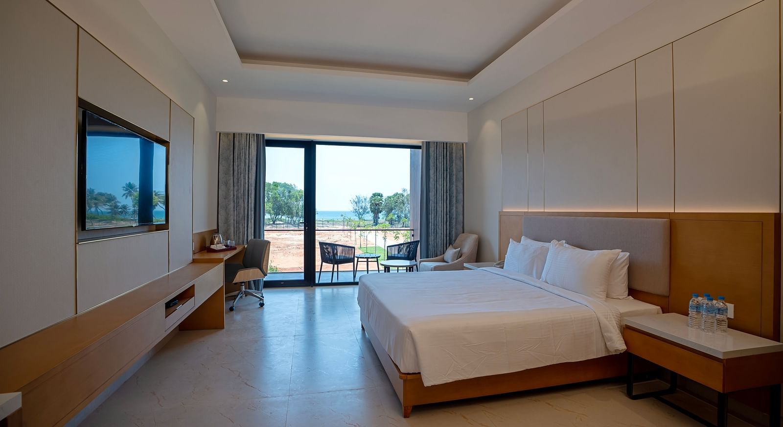 A spacious room of the Bay View Bliss at The Shore, Trishvam with ample of natural light coming from the french windows.