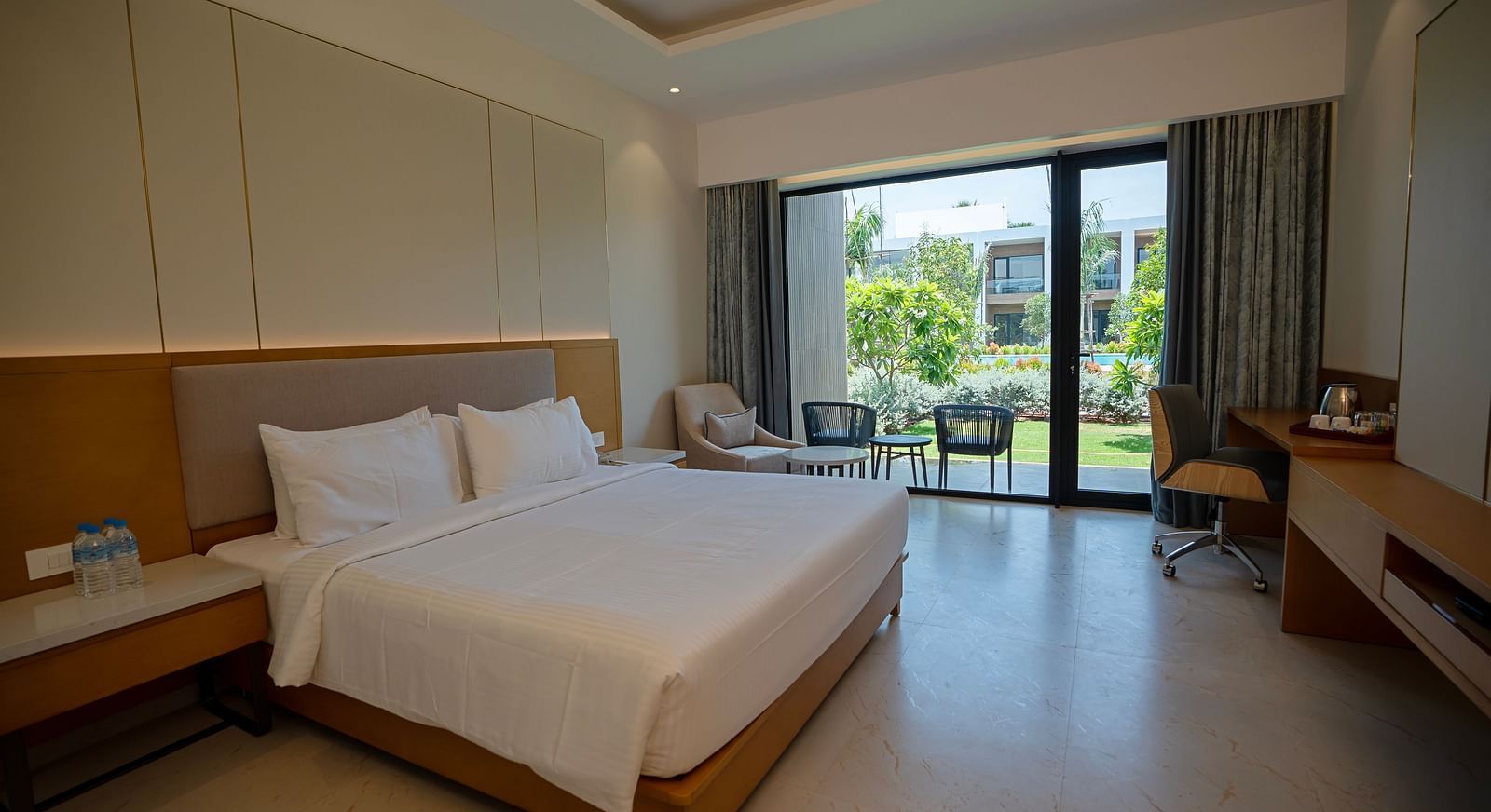 The Garden Courtyard room with huge french windows in the corner of the room at The Shore, Trishvam.
