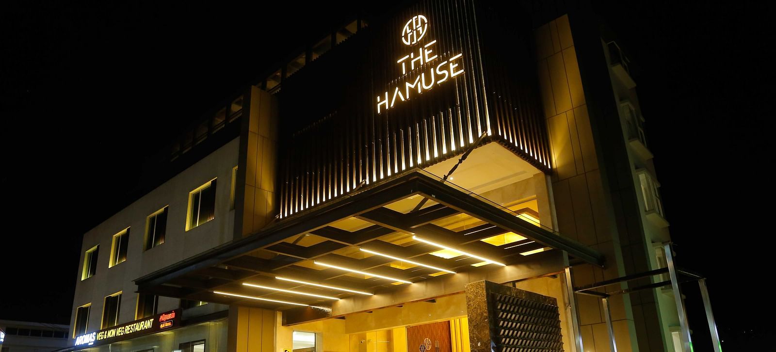 The Hamuse Hotel, Kodaikanal facade view showcasing parking space under a night sky.