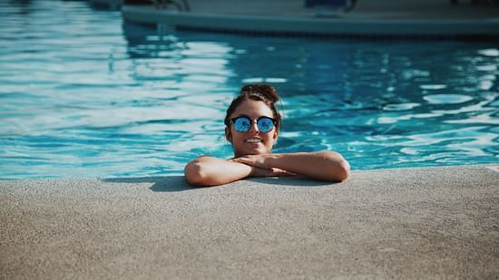 a woman smiling from a swimming pool