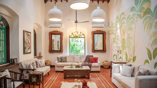 A living area with sofas and centre tables, photo frames on the wall, tables on each corners where decorative items are placed at Lamrin Ucassaim Hotel, Goa
