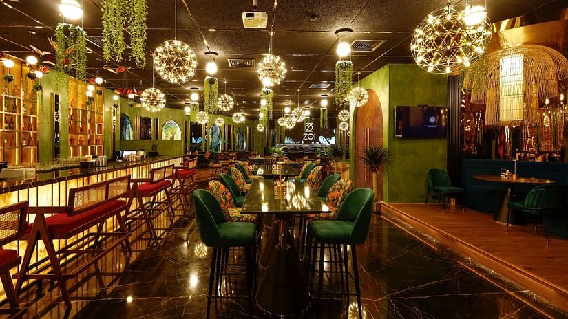An image of a well lit restro bar with several chairs and table