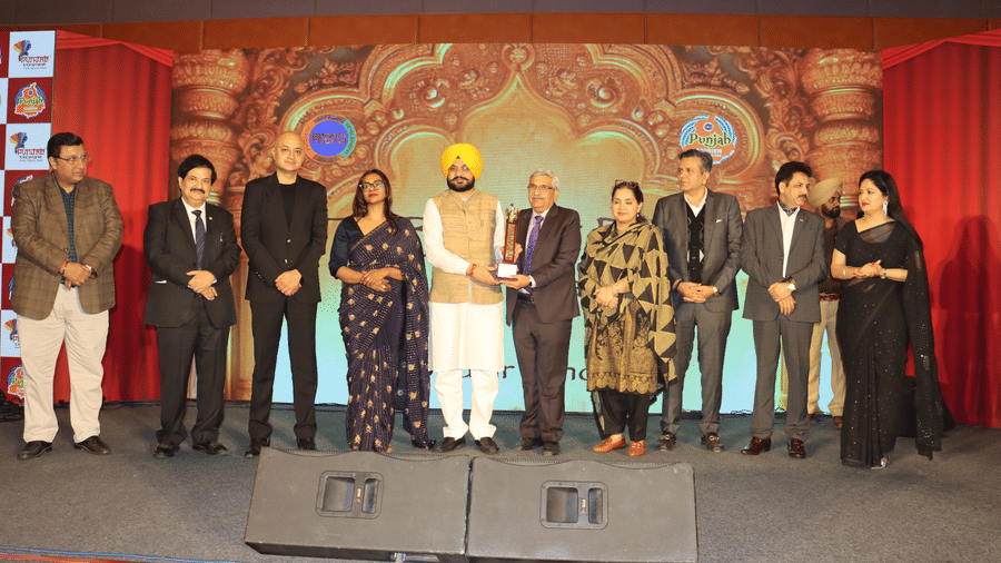 A group of people on a stage with ambient lighting and professional attire during an award ceremony