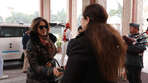 A woman wearing glasses extends her hand to greet another woman. - Heritage Village Resorts & Spa
