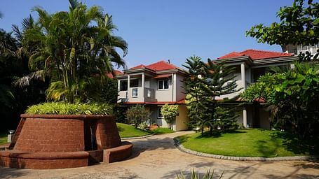 A facade image of a property which has various trees and a building amidst - Argo By Trance, Goa